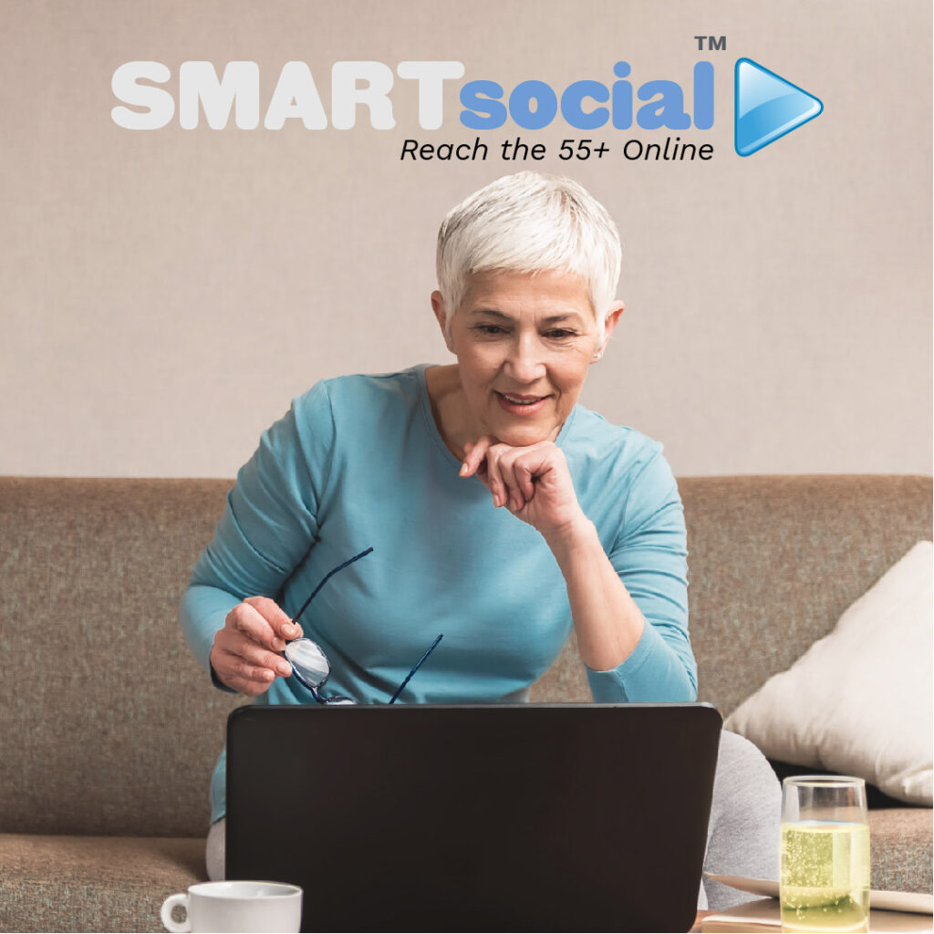 MATURE WOMAN ON SOFA WITH COMPUTER WITH SMARTSOCIAL LOGO